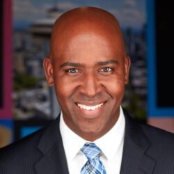 A man in a suit and tie smiling for the camera.