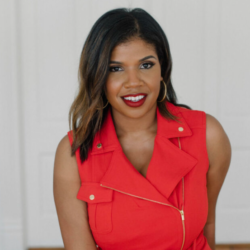 A woman in red is smiling for the camera.